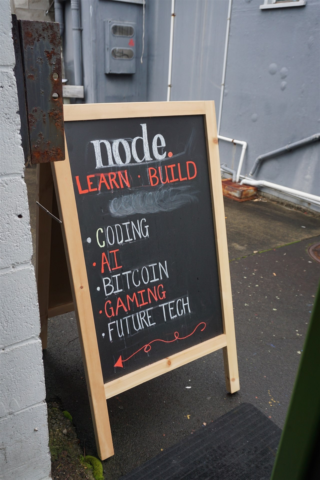 Node chalkboard A-frame sign outside the space